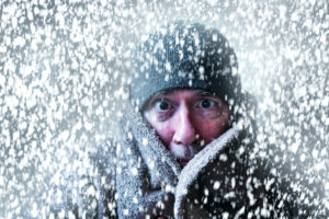 Person bundled up in the snow with coat and hat on