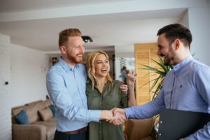Attic insulation sales tech greeting man and woman inside their home