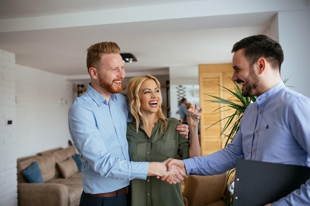 Electrical sales tech greeting man and woman inside their home