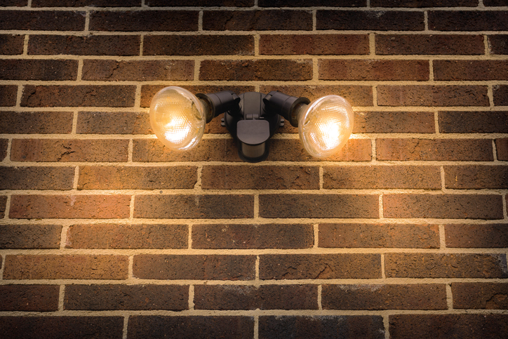 Black flood security light on external brick wall of a home