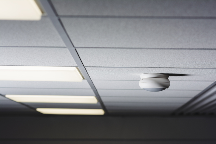 Detector mounted on the ceiling for programmed motion sensor lights in office