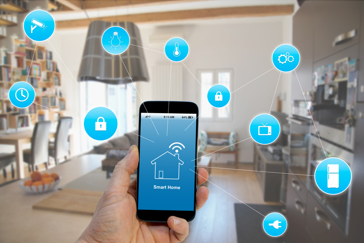 Hand holding smartphone with smart home application on screen for home automation devices