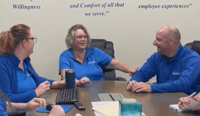 team of three john betlem employees talking at a table