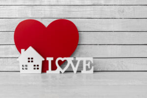 Home Shaped with Love Alphabet and Red Heart Shaped on white wood over white wood background