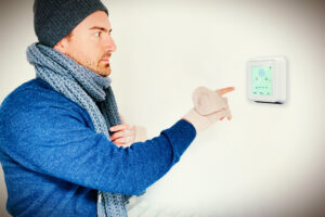 man adjusting a thermostat