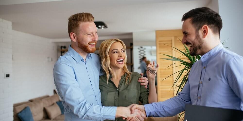 Electrical sales tech greeting man and woman inside their home